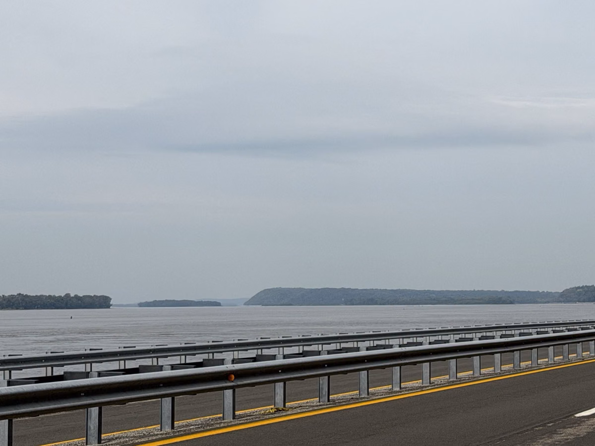 The divided river road out of Alton with the wide Mississippi River beyond on an overcast day