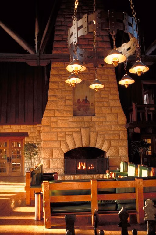 The tall stone fireplace and timber-beamed great room of Pere Marquette Lodge